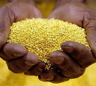 Cupped hands holding fine gold granules